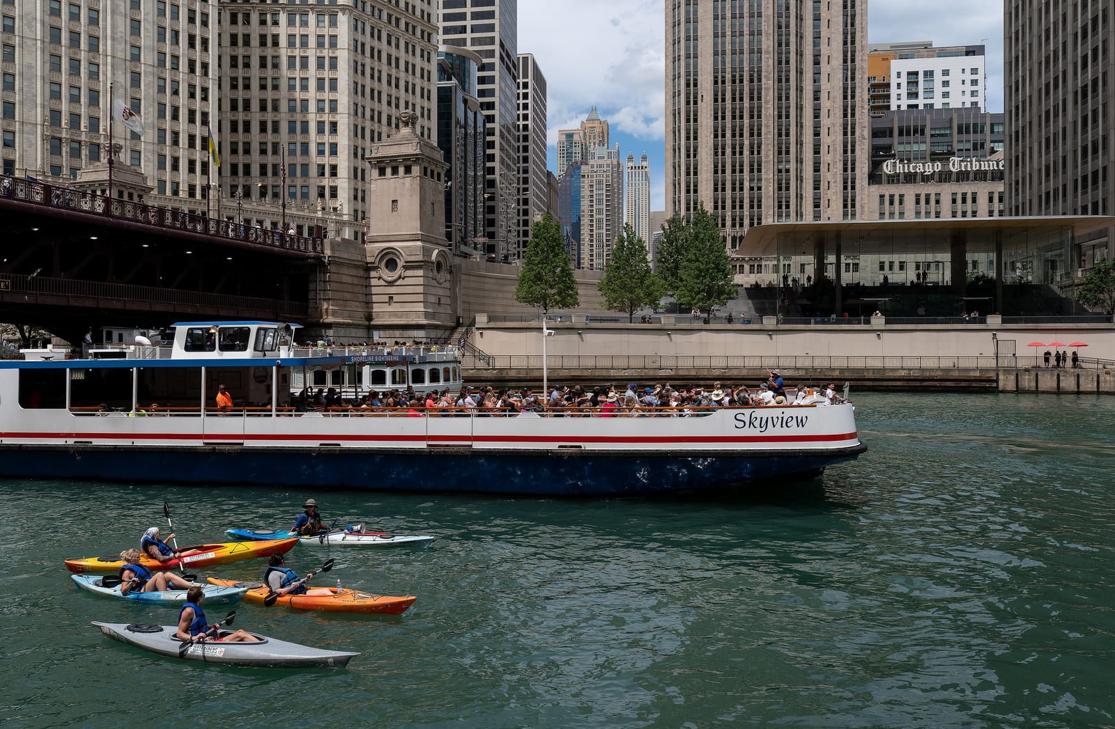 Tour boats and kayaks on the Chicago River along the downtown Chicago Riverwalk