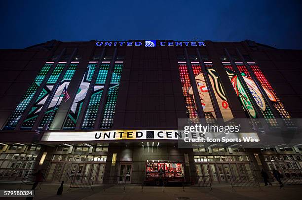 Exterior view of the United Center in Chicago illuminated at night, featuring sports-themed LED displays on the facade.