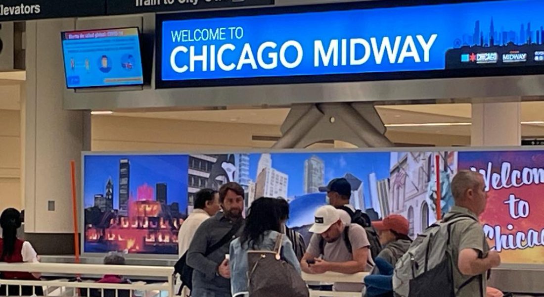 Passengers at Chicago Midway International Airport under a 'Welcome to Chicago Midway' sign, near transportation options including taxis, limos, shuttles, and rental car services.